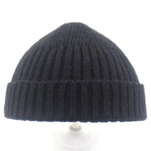 Minimalist black knit beanie with fine rib texture shown on a mannequin head stand