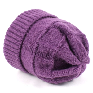 Dettaglio del berretto in maglia viola scuro con trama di lana spessa e bordo a coste