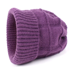 Dettaglio del berretto in maglia viola scuro con trama a coste verticali in lana