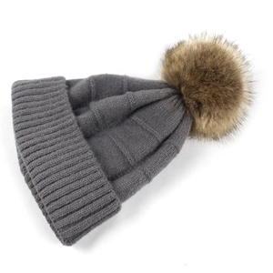 Klassische graue Strickmütze mit einem großen flauschigen Kunstpelz-Bommel