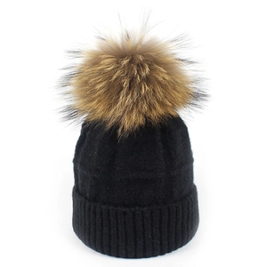 Vista detallada del gorro de lana negro para mujer con un gran pompón de piel esponjoso