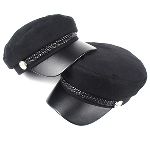 Detail of newsboy cap with leather brim, braided rope decor and gold side buttons