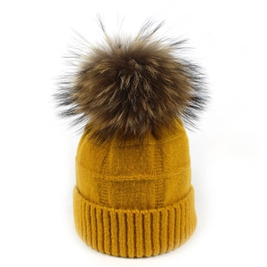 Detalle del gorro de punto amarillo jengibre con patrón de gofre y pompón de piel auténtica
