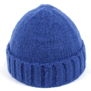 Dettaglio del berretto in maglia blu scuro che mostra la trama a coste e il tessuto caldo
