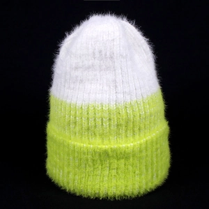 Detailed texture of white and neon green faux mink fur knitted winter beanie hat
