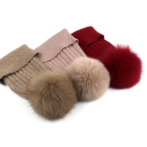 Dettagli di cappelli in maglia a coste color kaki, rosa e bordeaux con pompon di pelliccia