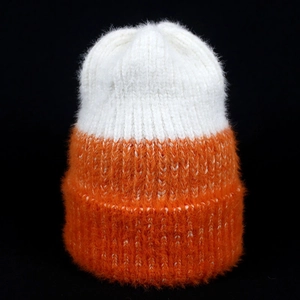 Detailed texture of white and orange faux mink fur knit beanie with ribbed cuff