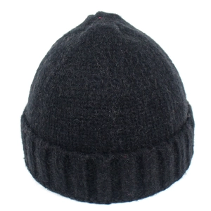 Dettaglio del berretto nero in maglia con texture morbida e risvolto a coste verticali