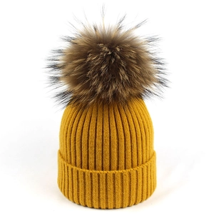 Gorro de punto amarillo con rayas verticales y pompón grande de piel sintética