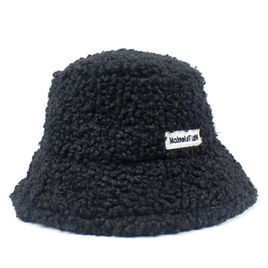 Detail of black teddy wool bucket hat showing thick lamb velvet texture and woven label