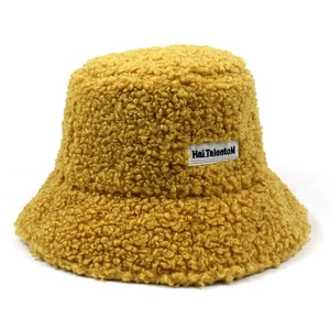 Detail of ginger yellow teddy fleece bucket hat showing plush texture and woven side label