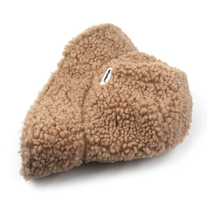Plush caramel lamb wool bucket hat with a white woven label on a clean white background
