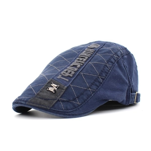 Close-up of navy blue cotton flat cap featuring M embroidery and quilted pattern design