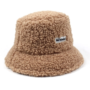 Close-up of thick sherpa texture and brand tag on a camel wool bucket hat