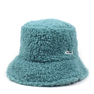 Detailed close-up of blue teddy faux fur bucket hat featuring a white woven side label