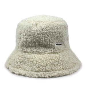 Detailed macro view of cream faux fur fabric texture and logo label on winter bucket hat