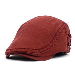 Detail of brick red cotton flat cap featuring side embroidery and adjustable metal buckle