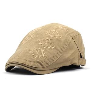 Detail shot of khaki newsboy cap featuring geometric embroidery and adjustable strap