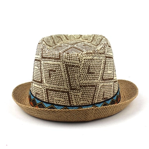Close-up of woven straw fedora hat featuring geometric check patterns and ethnic band