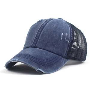Detail of distressed vintage baseball cap showing mesh fabric and frayed denim edges