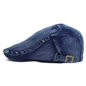 Detail of adjustable brass buckle and washed denim texture on dark blue flat cap