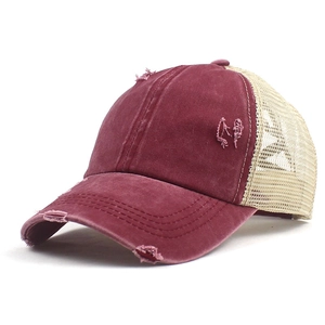 Detail of vintage burgundy baseball cap with mesh back and distressed frayed brim details