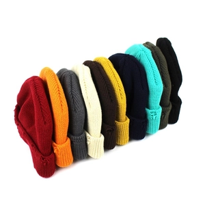 Distressed knit beanies in various colors featuring ribbed texture and stylish torn edges