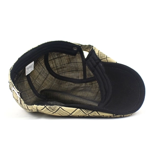 Close-up of beige plaid cotton beret showing internal black sweatband and 100% cotton label