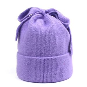 Close-up of a purple knitted beanie featuring a large bow and fine ribbed texture