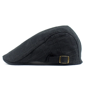 Detail of black cotton beret showing plaid texture and vintage metal side buckle