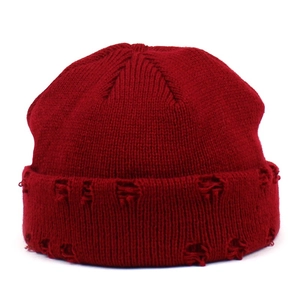 Detail of burgundy distressed knit beanie showing vertical ribbing and torn hole design