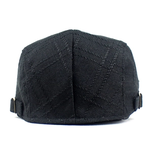 Detail of adjustable metal buckles and cross stitching on linen flat cap rear view