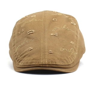 Detailed view of khaki distressed cotton beret with fashion embroidery and frayed holes