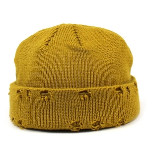 Close-up of mustard yellow knitted beanie featuring distressed ripped detailing and ribbed texture