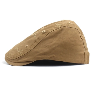 Detailed view of the distressed cotton fabric with fashion embroidery on the khaki flat cap