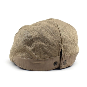 Détail du béret marron respirant avec tissu en maille géométrique et boutons pression