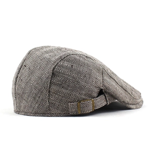Detail of herringbone pattern fabric and bronze adjustable buckle on the vintage beret