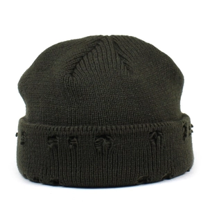 Detail of distressed ripped edges on olive green knitted winter beanie cap