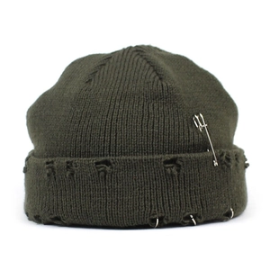 Detail of army green distressed knit beanie with silver safety pin and metal rings