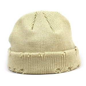 Trendy beige ribbed knit beanie with distressed hole details for a winter street style look