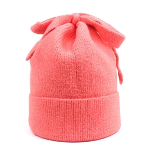Close-up of pink knit beanie with bow detail and fuzzy mohair texture for winter
