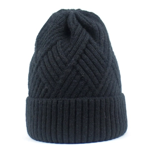 Detail of black knit beanie featuring geometric diamond texture and ribbed cuff design
