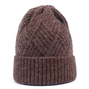 Detailed close-up of dark brown knit beanie showing thick diamond pattern weave texture