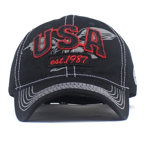 Macro view of red USA embroidery and white contrast stitching on black baseball cap