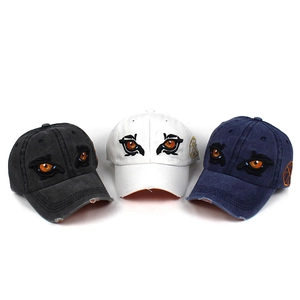 Detailed close-up of washed cotton baseball caps with distressed brims and eagle eye embroidery