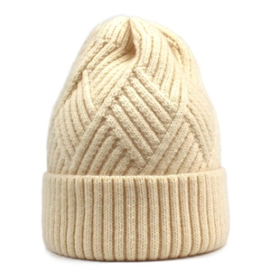 Detailed view of cream knit beanie featuring cross-stitch diamond texture and ribbed cuff