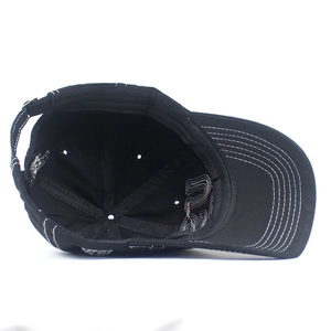 Detailed interior of black cotton baseball cap showing six-panel stitching and white seam lines
