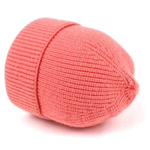 Detail view of coral pink ribbed knit beanie showing soft textured fabric and folded cuff