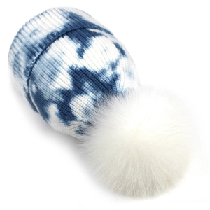 Bonnet en tricot tie-dye bleu et blanc avec un pompon en fausse fourrure blanche pour l'hiver