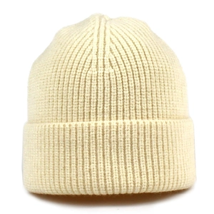 Detailed view of the thick cream knit texture and folded rim on a ribbed beanie hat